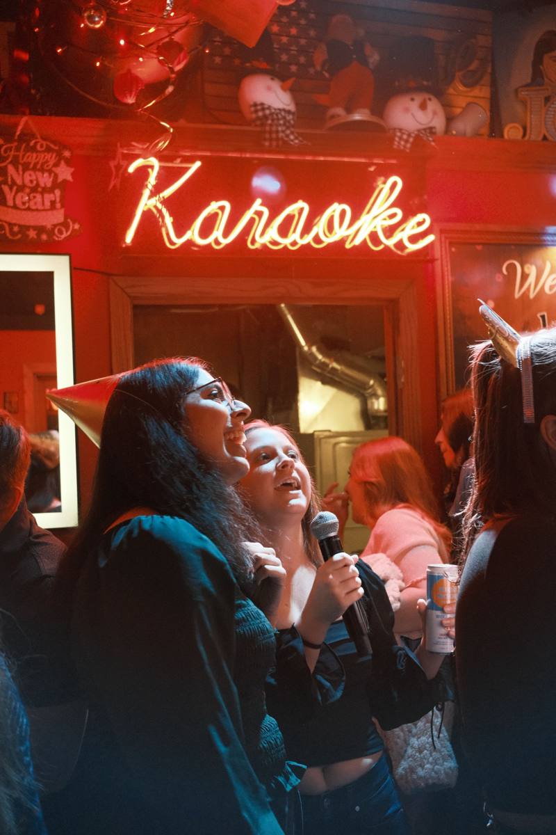 Un grupo de amigos cantando en un karaoke