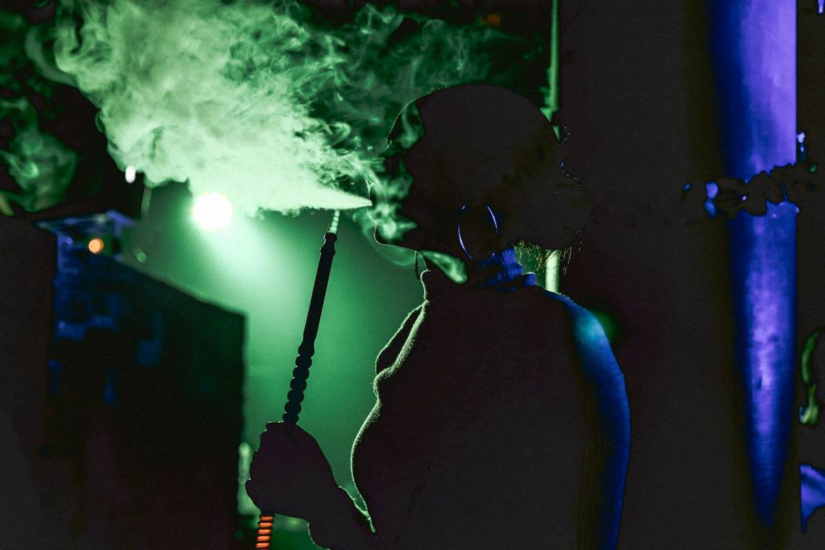 Persona con una shisha bajo luz de neón