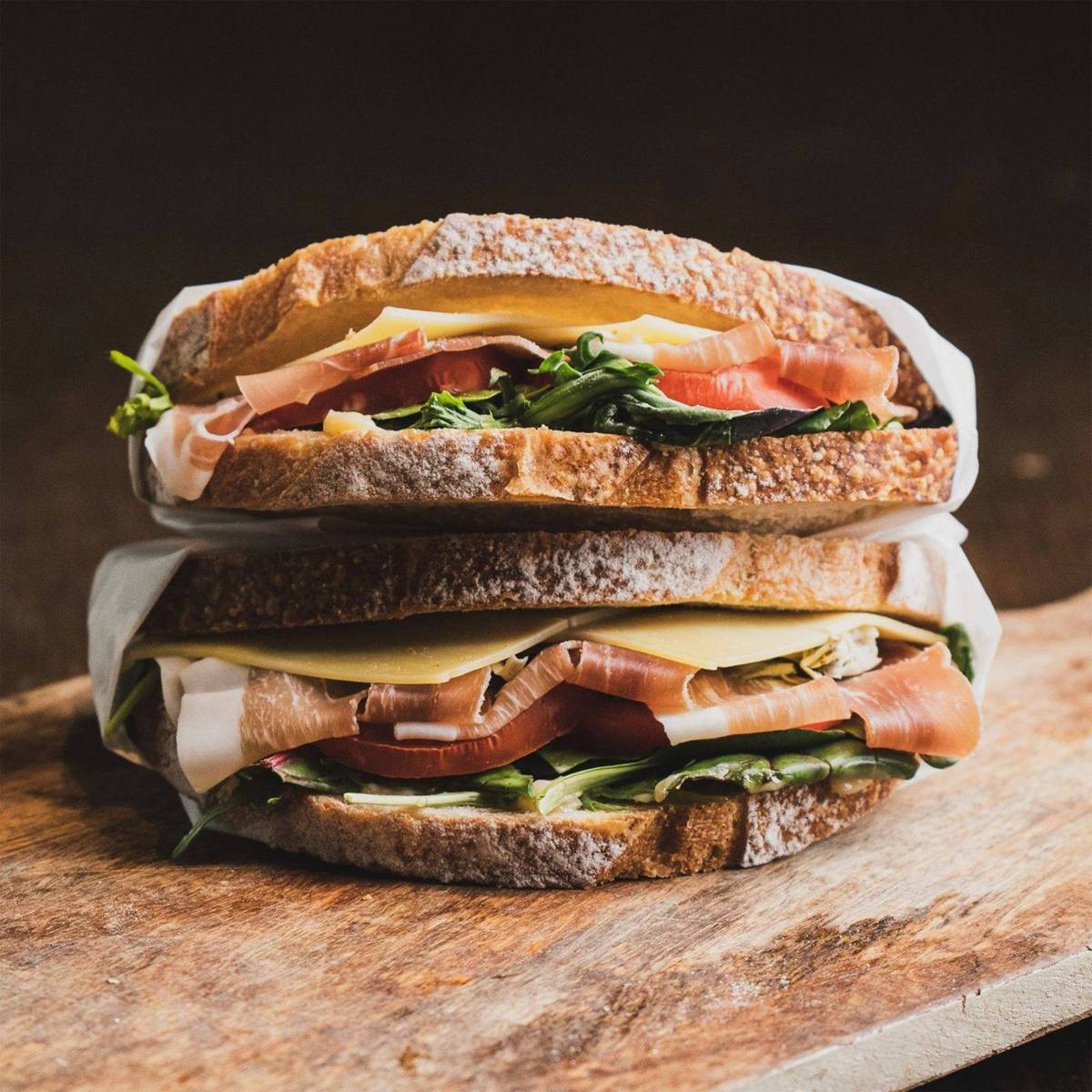 Bocadillo de jamón, queso y verdura sobre madera
